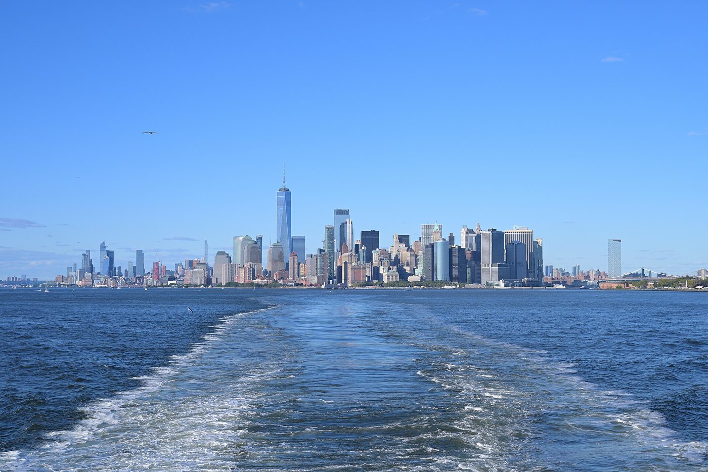 Les gratte-ciel de Lower Manhattan vus depuis le ferry gratuit de Staten Island, sillage au premier plan