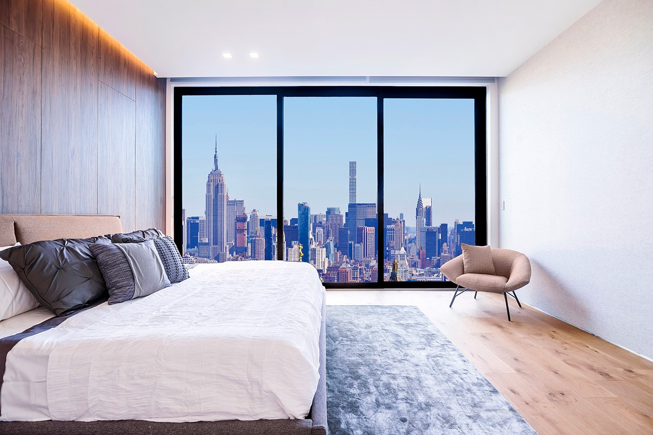 Chambre d'hôtel avec baie vitrée donnant sur l'Empire State Building et les gratte-ciel de Midtown