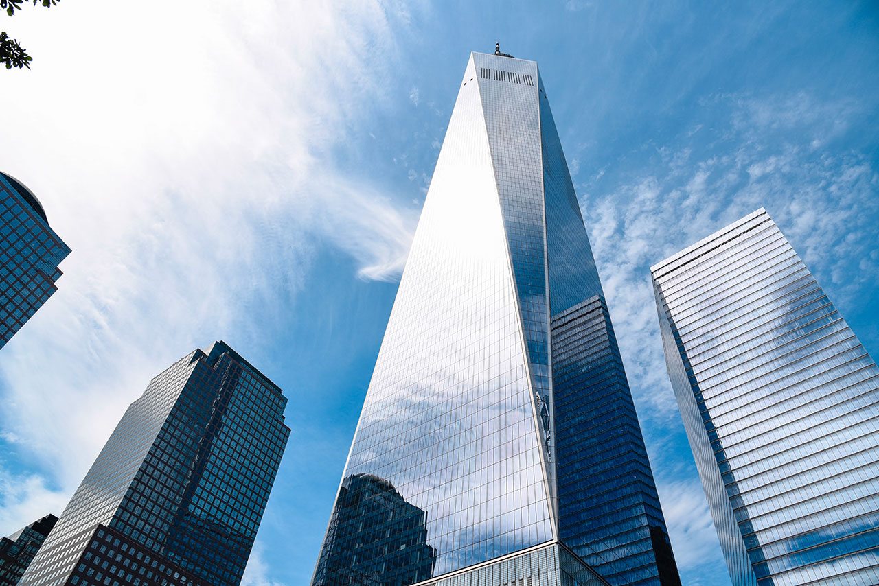 La tour One World Trade Center vue d'en bas, entourée d'autres gratte-ciel