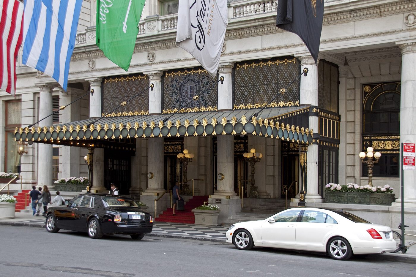 Entrée du Plaza à New York, avec sa marquise noir et or, ses drapeaux et deux berlines garées devant